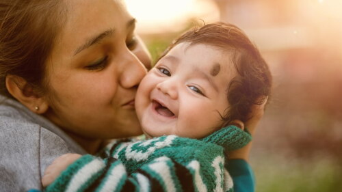 Mom kissing smiling baby.jpeg